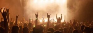 silhouettes of concert crowd in front of bright stage lights